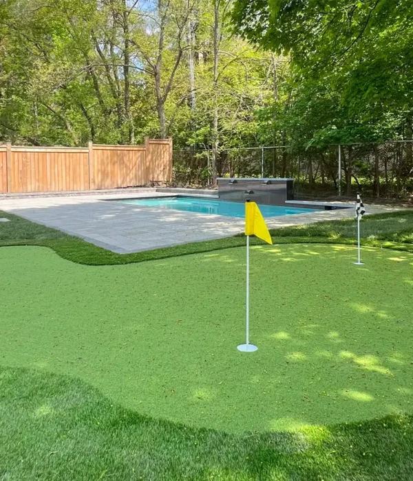 A putting green installed in the backyard of a client's home in Etobicoke next to their pool