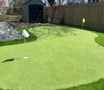 A putting green installed in the backyard of a client's home in Etobicoke next to their pool