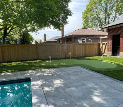 A putting green installed in the backyard of a client's home in Etobicoke next to their pool