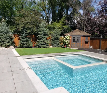 A putting green installed in the backyard of a client's home in Mississauga next to their pool