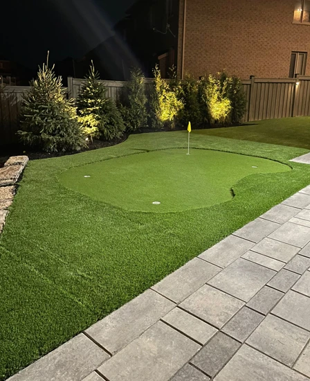 A putting green installed in the backyard of a client's home next to interlocking
